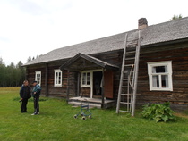 Paikallislehden toimittaja Mustonen jututtaa kotiseutuneuvos Juntusta päärakennuksen edessä.